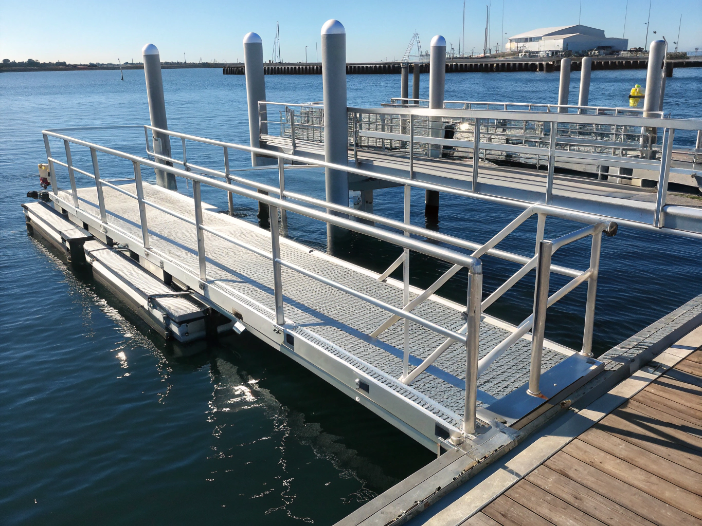 Marine-grade stainless steel utility pedestals and waterproof enclosures along a harbor boardwalk