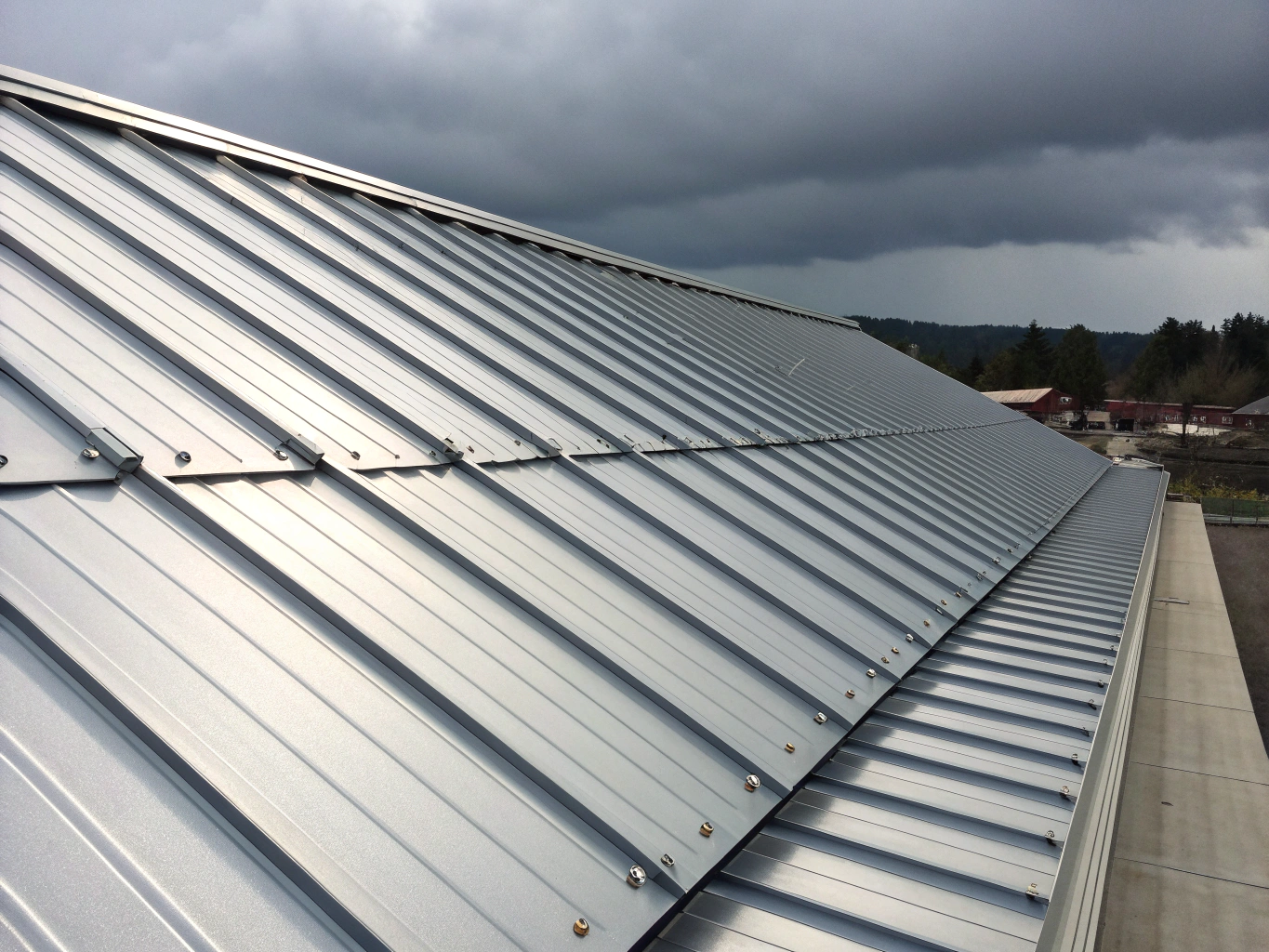 Metal roofing components including flashing and drainage channels